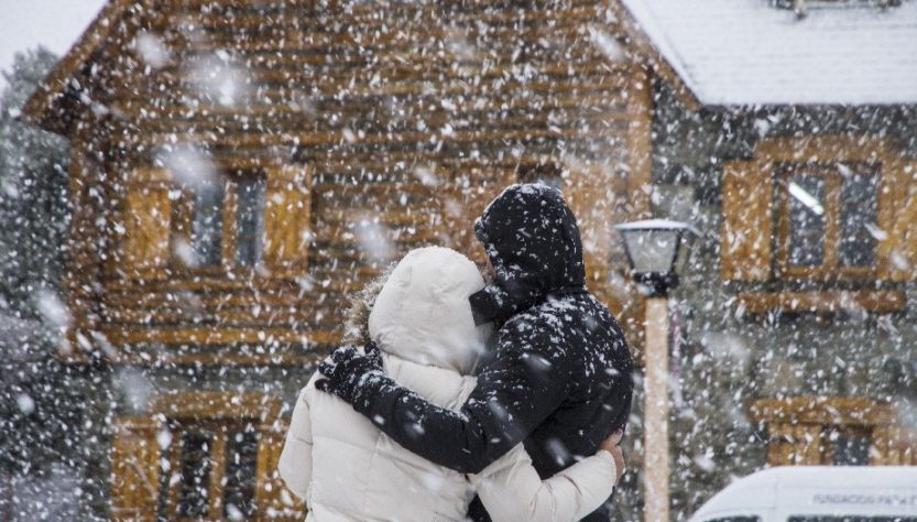 dos personas abrazadas en la nieve en Bariloche