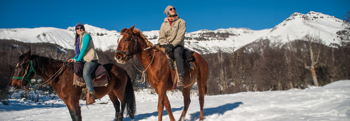 pareja a caballo en la nieve