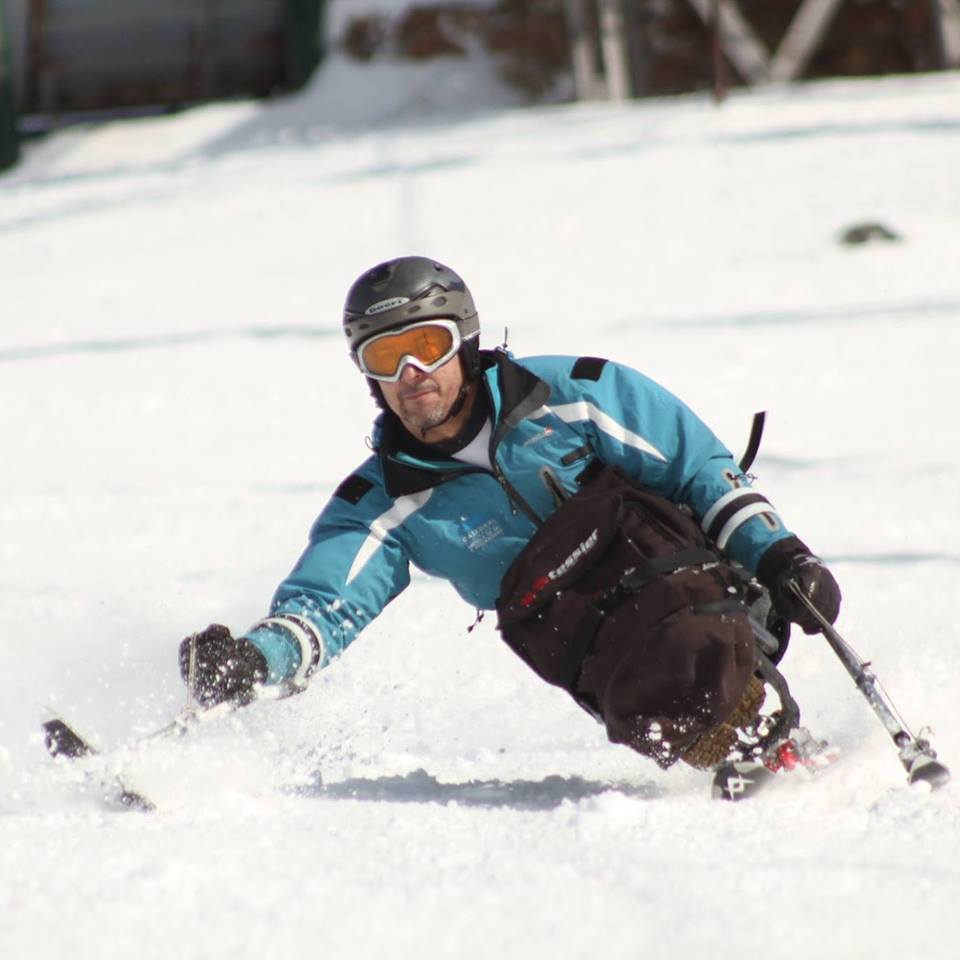 Germán Vega, el primer instructor de esquí en silla de ruedas del mundo, descendiendo de la montaña con equipos adaptados.