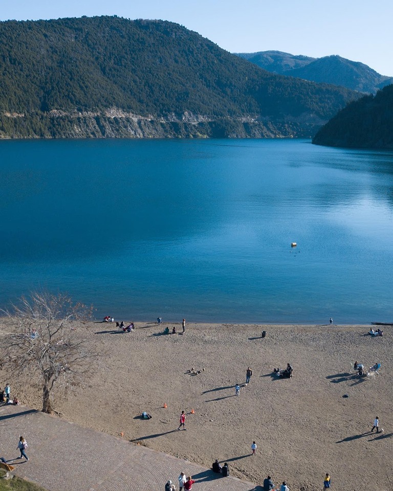 Costa del lago Lácar con personas paseando