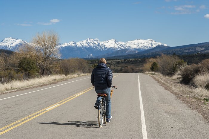 Hombre andando en bicicleta con la montaña de fondo en Esquel.