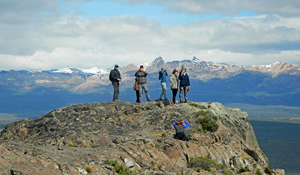 Grupo de personas sobre una roca, observando desde las alturas.