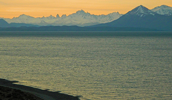 Lago y montañas de fondo al atardecer. 