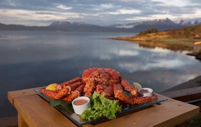 Plato de centolla con vista panorámica del canal de Beagle en Puerto Almanza.