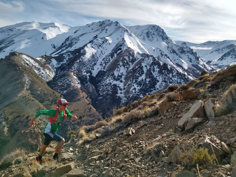 Hombre subiendo a la cima de la montaña. Esquel y Trevelin se posicionan para el verano.