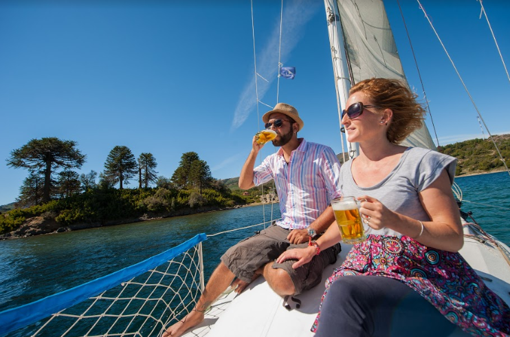 Pareja tomando cerveza a bordo de un velero.