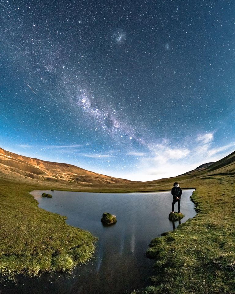 Hombre parado mirando el cielo realizando la experiencia nocturna en El Calafate.