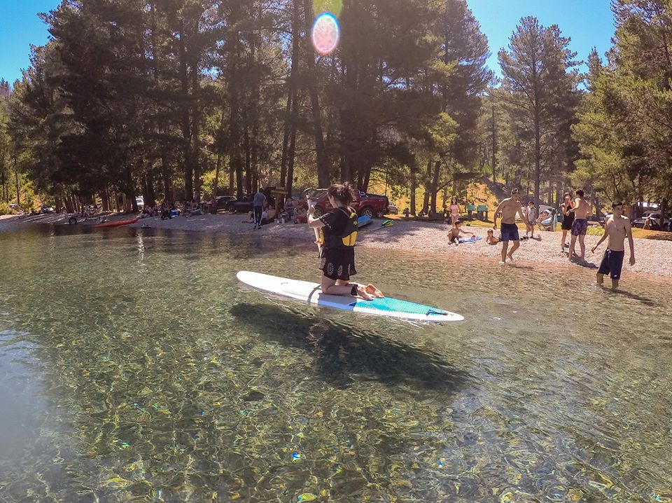 Mujer remando sobre las aguas del lago Epuyén