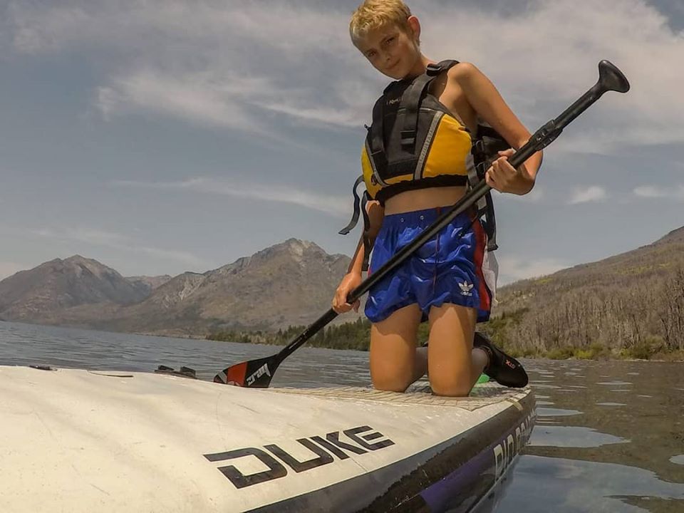 Niño remando haciendo Stand Up Paddle.