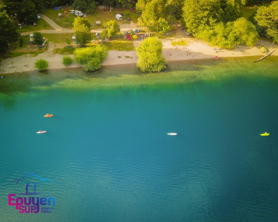 Panorámica del lago Epuyén con personas realizando Stand Up Paddle.