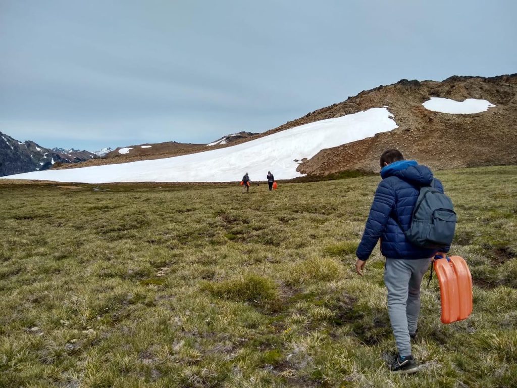 Personas yendo a la nieve en verano en el cerro Perito Moreno de El Bolsón.